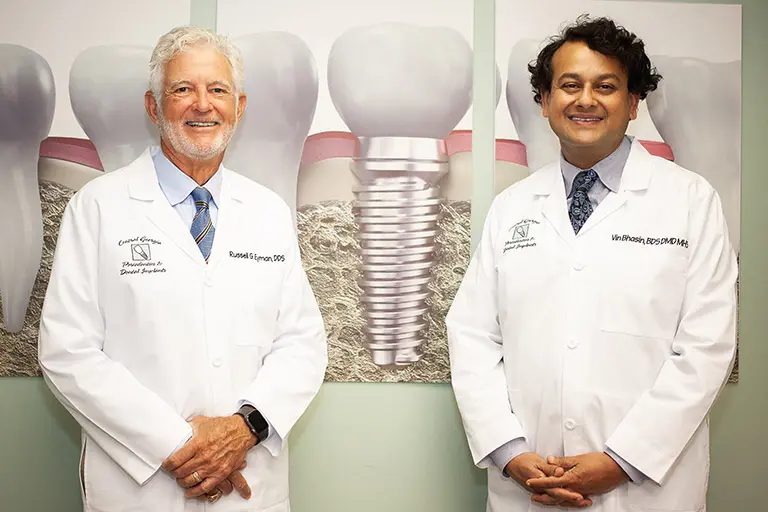 Image of Dr. Bhasin and Dr. Eyman standing side-by-side in white coats, smiling.